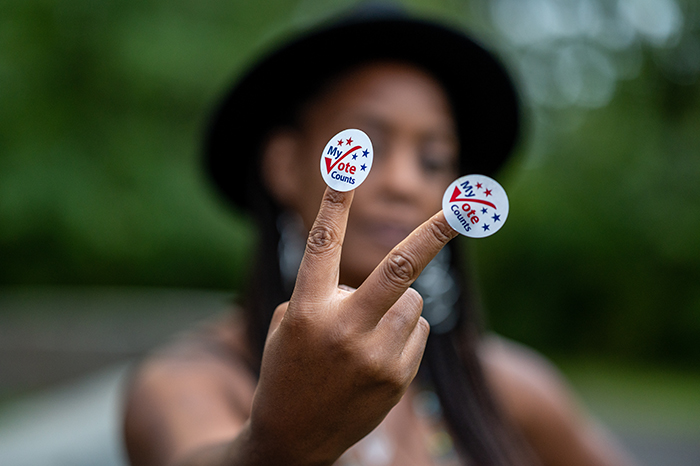 Black woman holding voting stickers