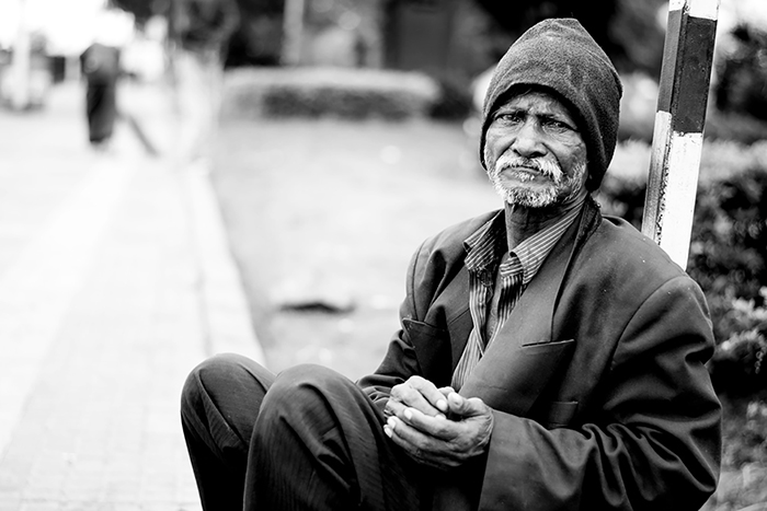 Older Black Man Sitting On Ground